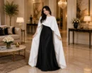Woman wearing black satin modest gown with white cape dupatta